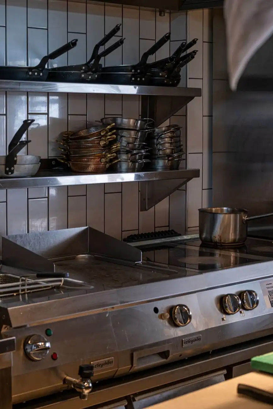 Cozinha industrial com fogão e panelas de inox