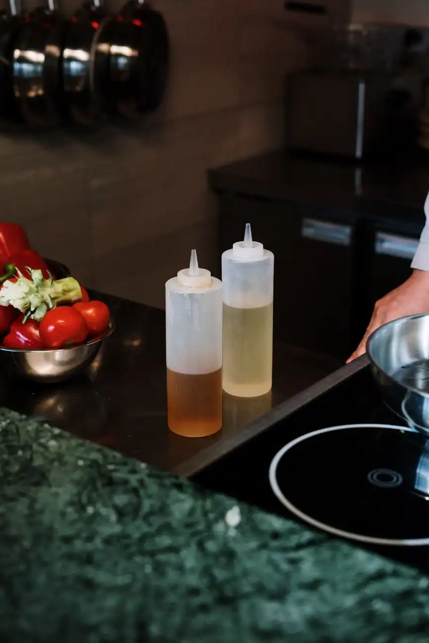 Garrafas de óleo e vegetais sobre a bancada de uma cozinha profissional