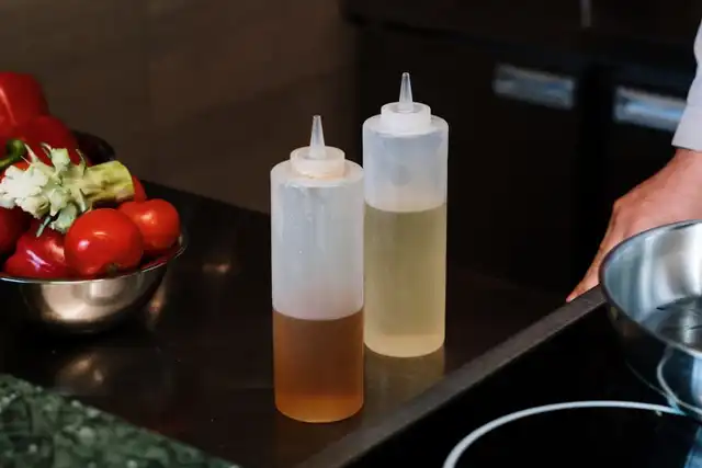 Garrafas de óleo e vegetais sobre a bancada de uma cozinha profissional
