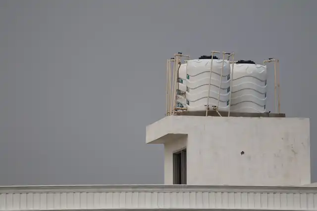 Reservatórios de água brancos instalados em um telhado residencial