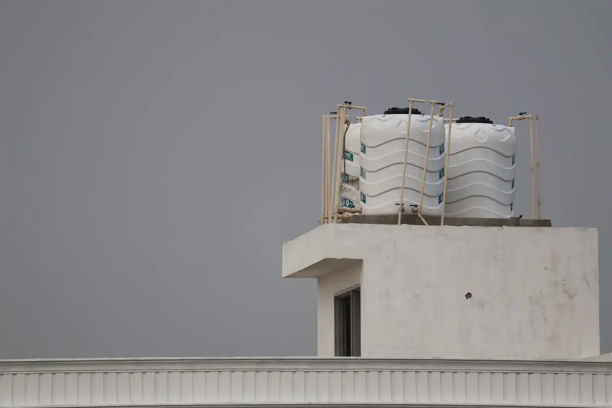 Reservatórios de água brancos instalados em um telhado residencial