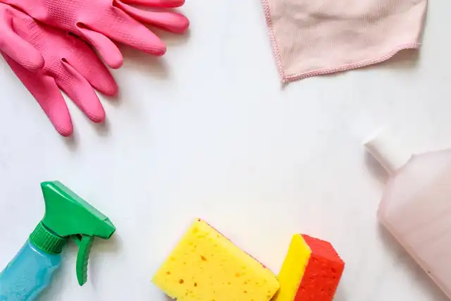 Produtos e utensílios de limpeza dispostos sobre superfície clara