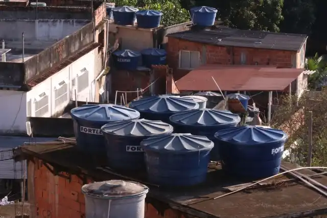Várias caixas d'água em telhados de uma área urbana densa
