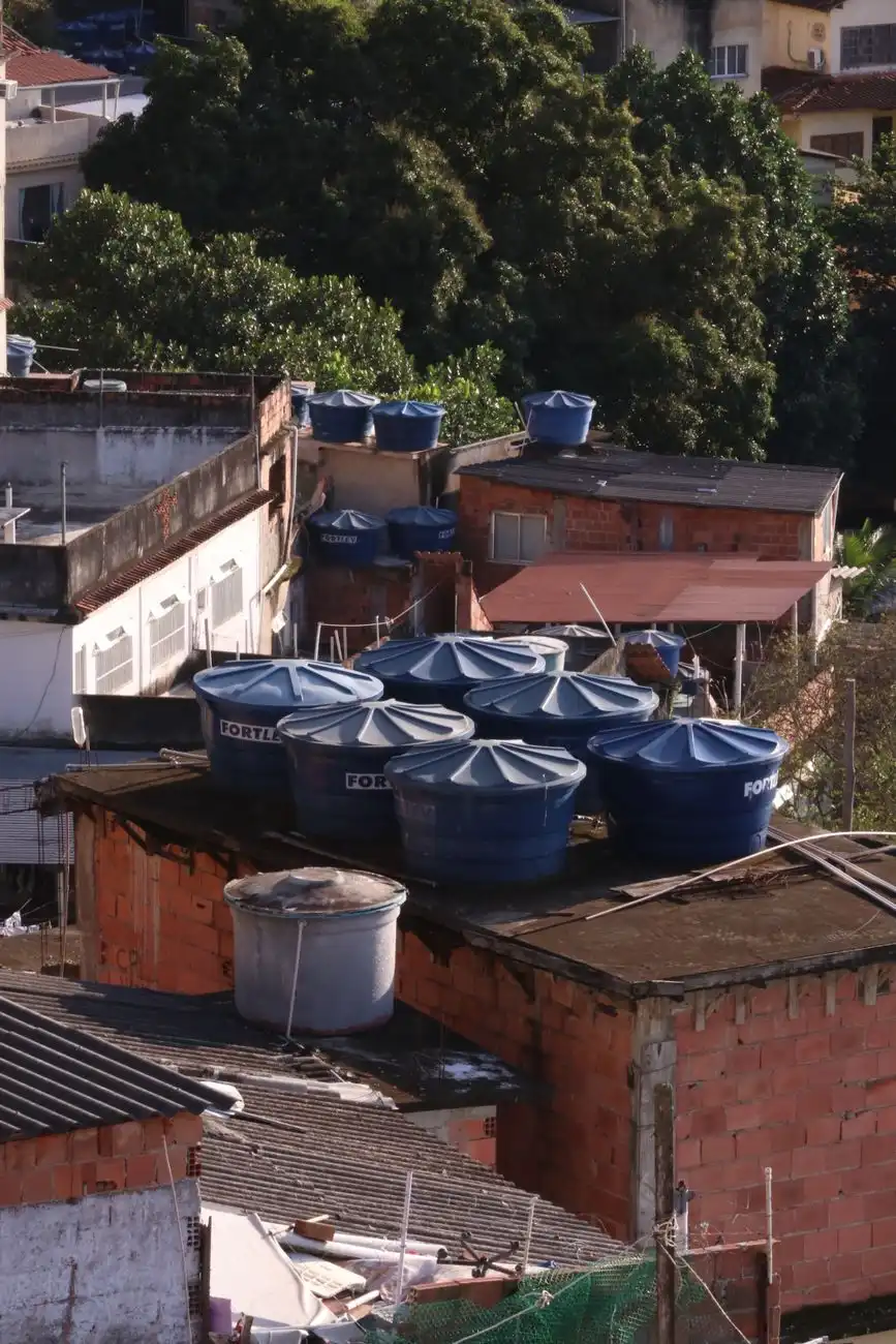 Várias caixas d'água em telhados de uma área urbana densa