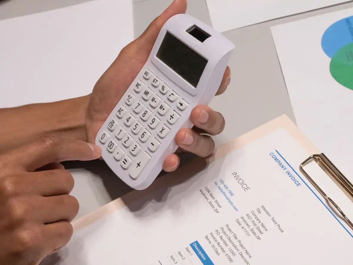 Pessoa usa calculadora ao lado de uma fatura